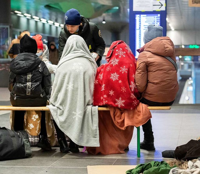 In Decken gehllt sitzen diese Kinder ... ehrenamtlicher Helfer um sie kmmert.  | Foto: Paul Zinken (dpa)