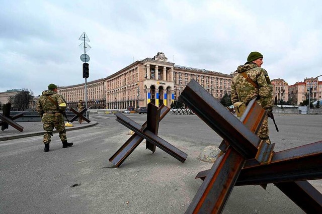 Reservisten der ukrainischen Armee ste...der Hauptstadt Kiew vor Panzersperren.  | Foto: SERGEI SUPINSKY (AFP)