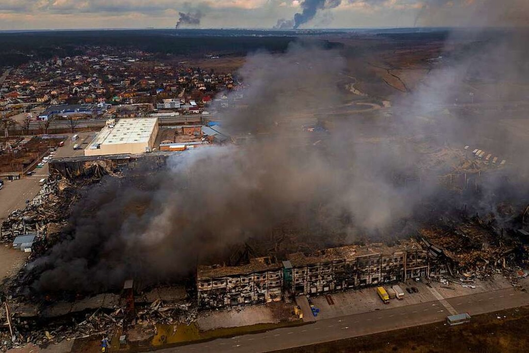 Eine Fabrik und ein Geschäft brennen n...griff in Irpin, einem Vorort von Kiew.  | Foto: Emilio Morenatti (dpa)