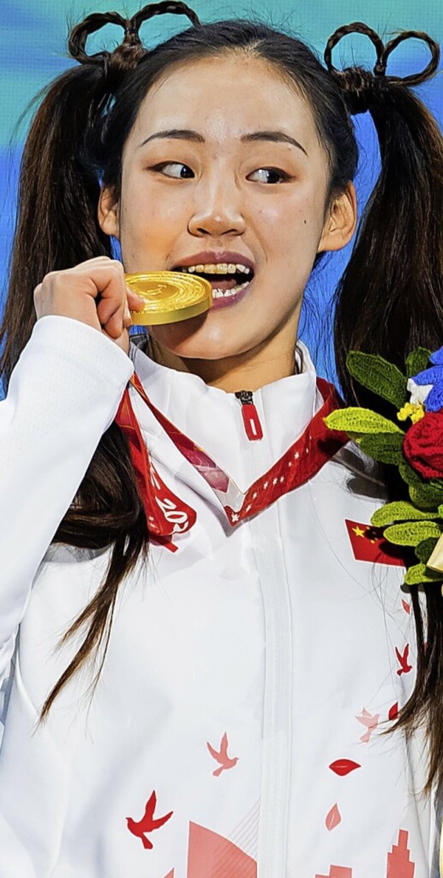 Die chinesische Alpinskifahrerin Zhang Mengqiu posiert mit ihrer Goldmedaille.  | Foto: Christoph Soeder (dpa)