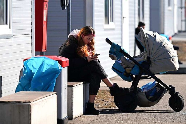 Eine Frau mit Kinderwagen sitzt in ein...chtung fr Geflchtete aus der Ukraine  | Foto: Hendrik Schmidt (dpa)