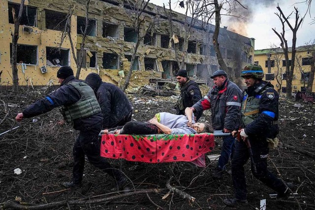 Ukrainische Rettungskrfte und Freiwil...h schweren Beschuss  beschdigt wurde.  | Foto: Evgeniy Maloletka (dpa)