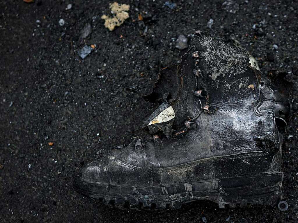 Ein verkohlter Stiefel liegt auf dem Boden neben einem zerstrten russischen Panzer in Irpin, am Stadtrand von Kiew.