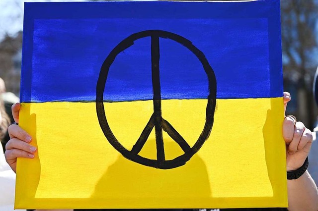 Das Peace-Zeichen auf einer Flagge der Ukraine &#8211; es steht fr Frieden.  | Foto: Arne Dedert (dpa)