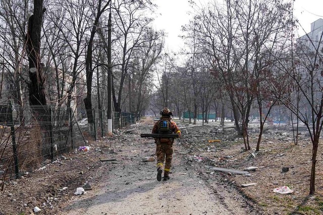 Ein ukrainischer Soldat geht nahe sein...t Mariupol nach Angaben aus Kiew fort.  | Foto: Evgeniy Maloletka (dpa)