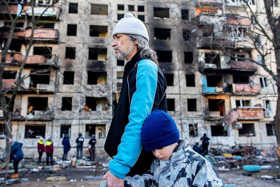 Kiew am heutigen Montag: Ein Vater und...angriff zerstörten Wohnkomplex vorbei.  | Foto: Seth Sidney Berry (dpa)