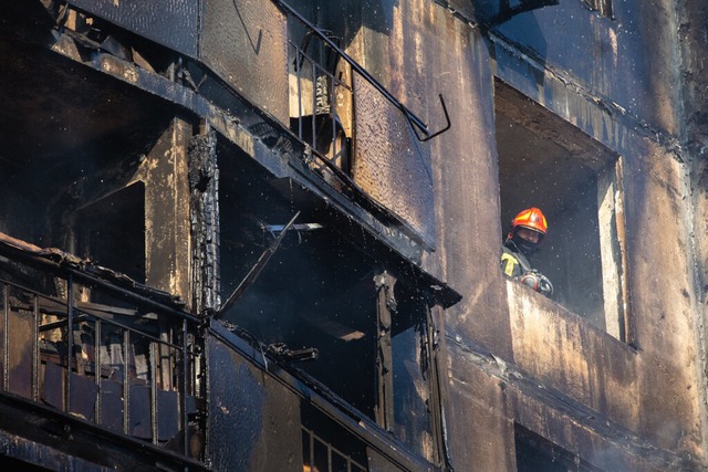 Ein Feuerwehrmann steht an einem Fenst...ch russischen Angriffen auf die Stadt.  | Foto: Mykhaylo Palinchak (dpa)