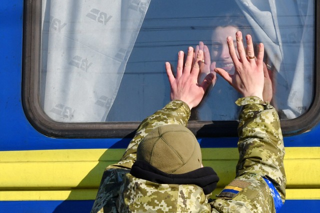 Ein ukrainischer Soldat verabschiedet ...kuierungszuges vom Bahnhof Kramatorsk.  | Foto: Andriy Andriyenko (dpa)