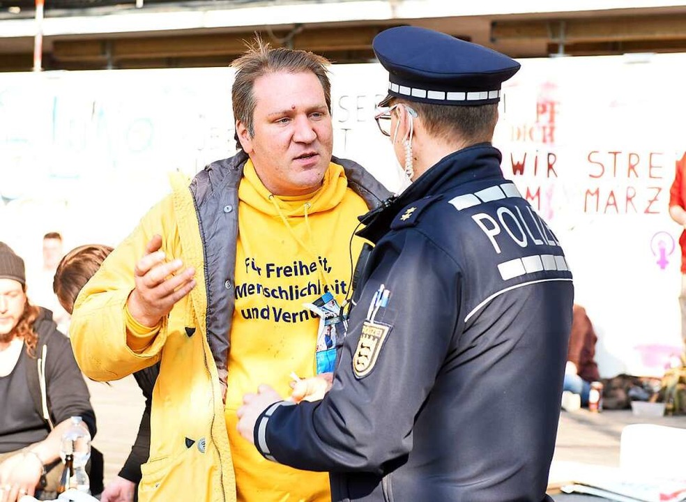 Veranstalter Malte Wendt diskutiert am...r Kundgebung mit einem Polizeibeamten.  | Foto: Rita Eggstein