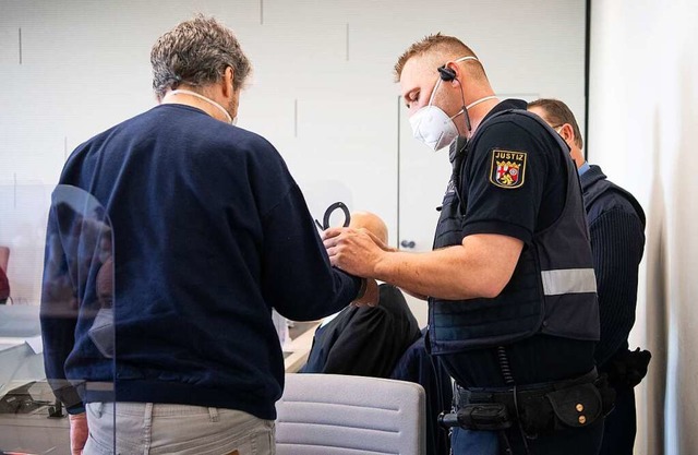 Ein Justizwachtmeister nimmt dem Angek...ingte Maskenpflicht hingewiesen hatte.  | Foto: Boris Roessler (dpa)