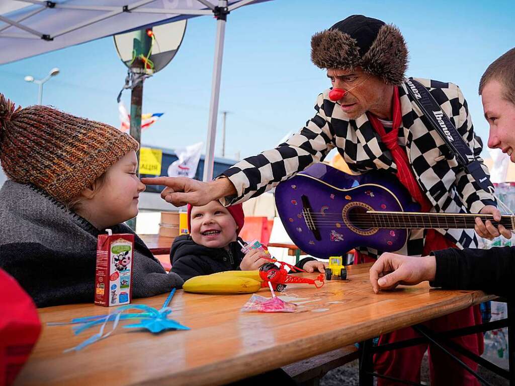 Polen, Medyka: Ukrainische Kinder werden am Grenzbergang in Medyka, Sdostpolen, von Javier Way Waka Katz, einem Clown der Organisation Dream Doctors aus Israel, unterhalten.