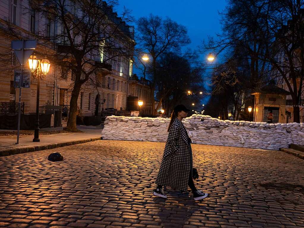 Odessa: Eine Frau geht an einer Barrikade aus Sandscken vorbei.