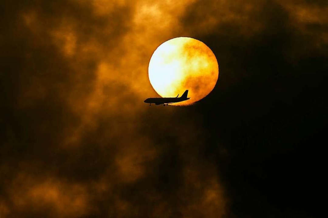 Ein Passagierflugzeug überfliegt ein s...nne in Jiddah, Saudi-Arabien, aufgeht.  | Foto: Hassan Ammar (dpa)
