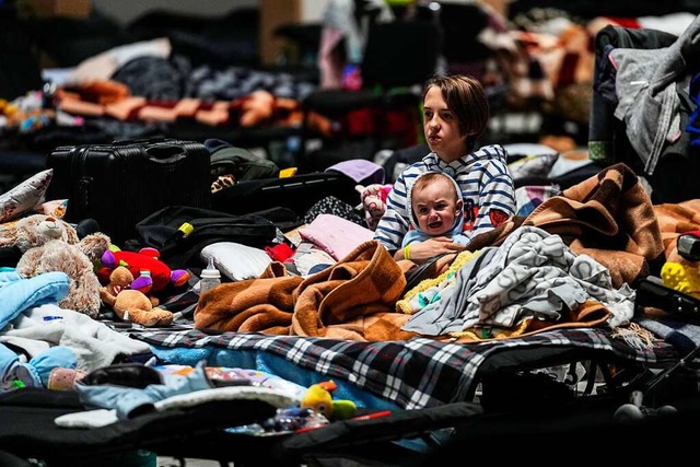 Das Flchtlingszentrum im polnischen N...aby im Arm in einem Haufen von Decken.  | Foto: Petr David Josek (dpa)