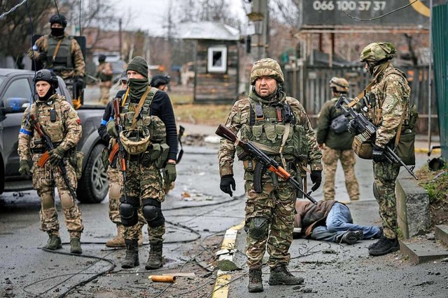 Ukrainische Soldaten stehen neben der ...sisch besetzten Kiewer Vorort Butscha.  | Foto: Vadim Ghirda (dpa)