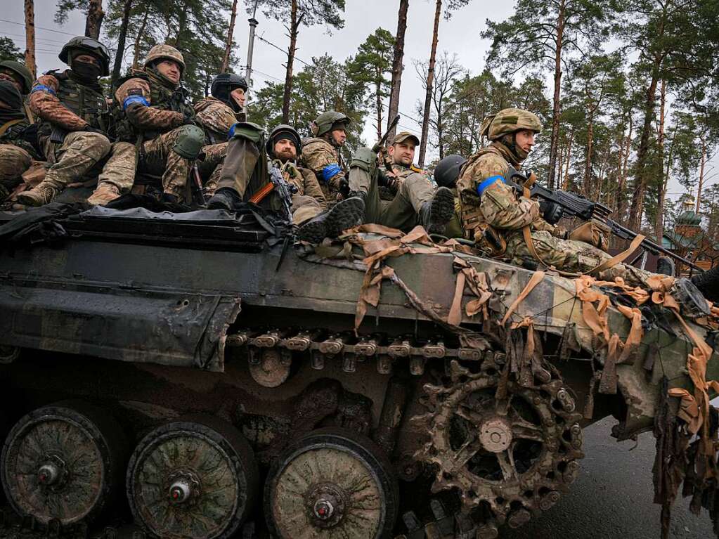 Ukrainische Soldaten fahren auf einem Kampffahrzeug auerhalb von Kiew.