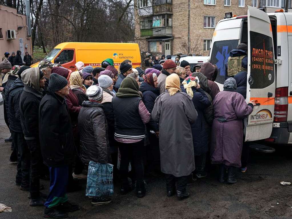 Menschen in Butscha warten auf die Verteilung von Medikamenten.