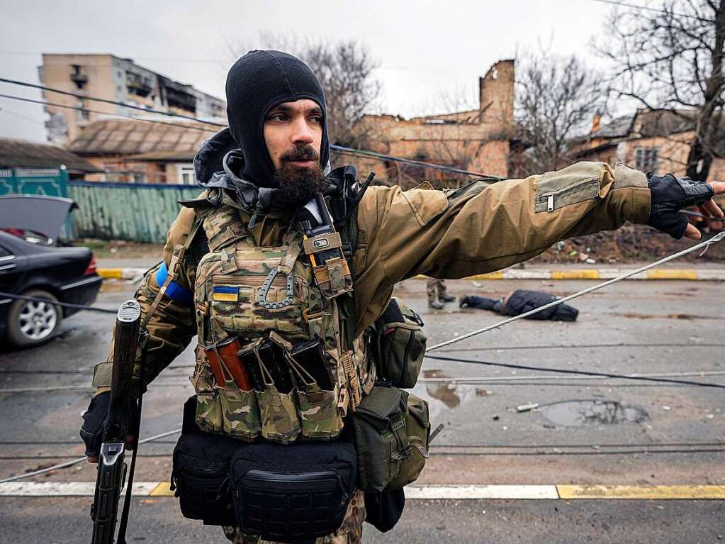 Ein ukrainischer Soldat gestikuliert, whrend seine Kameraden nach Sprengfallen suchen.