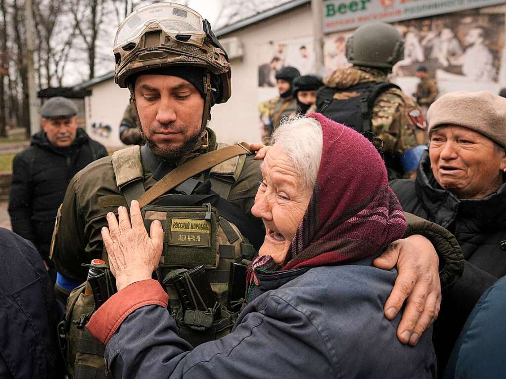 Eine Frau umarmt einen ukrainischen Soldaten.