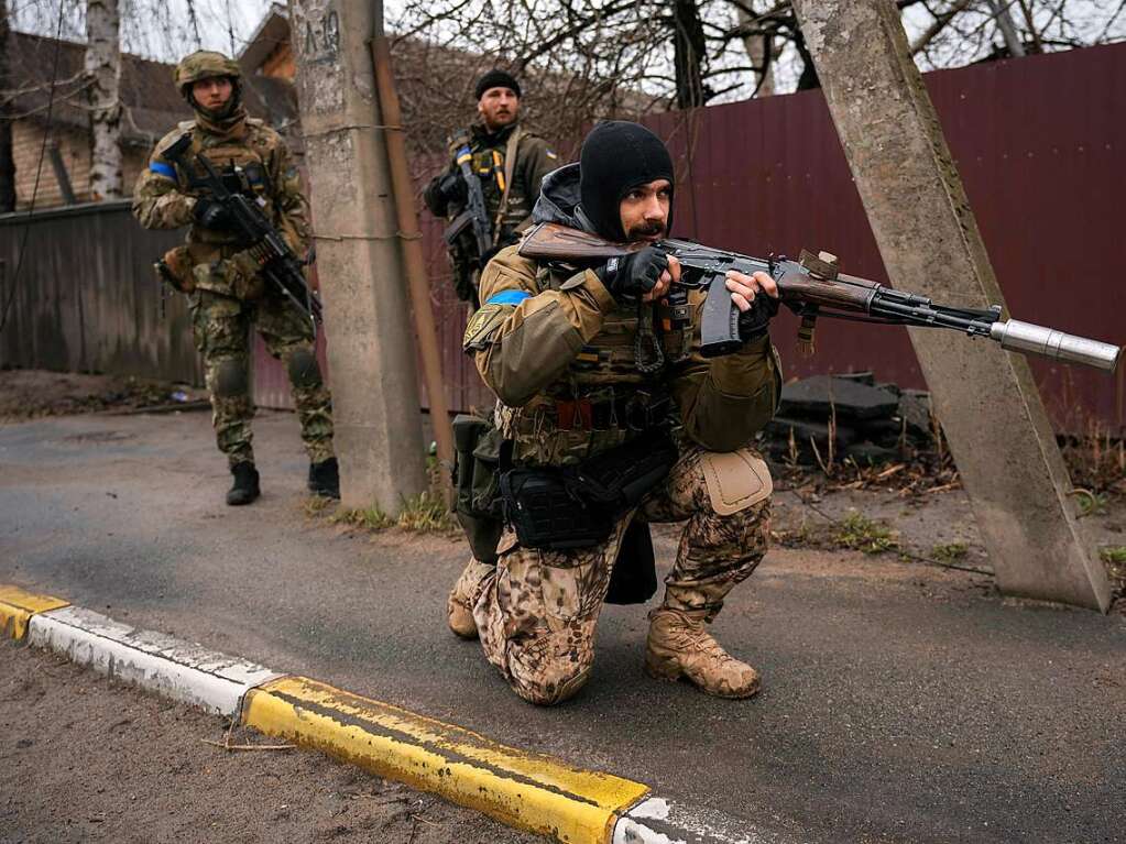 Ein ukrainischer Soldat sichert den Rckzug seiner Kameraden, die in dem ehemals russisch besetzten Kiewer Vorort Butscha  auf der Strae liegende Leichen auf Sprengfallen untersucht haben.