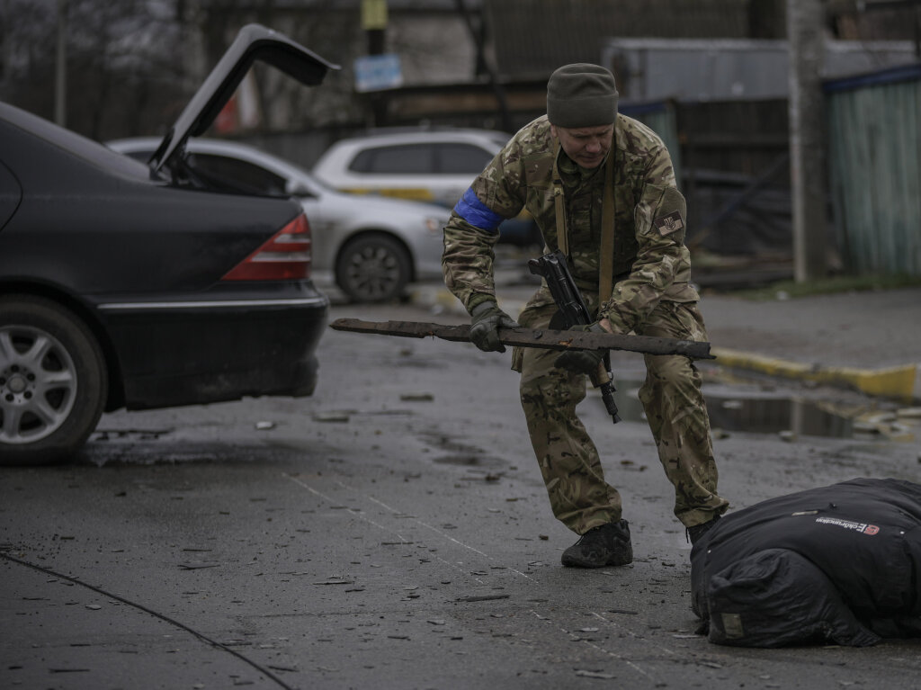 Ein ukrainischer Soldat untersucht den leblosen Krper eines Zivilisten auf Sprengfallen in dem ehemals russisch besetzten Kiewer Vorort Butscha.