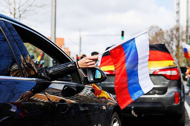 Eine russische Flagge wird auf auf dem...nnover aus einem Autofenster gehalten.  | Foto: Michael Matthey (dpa)