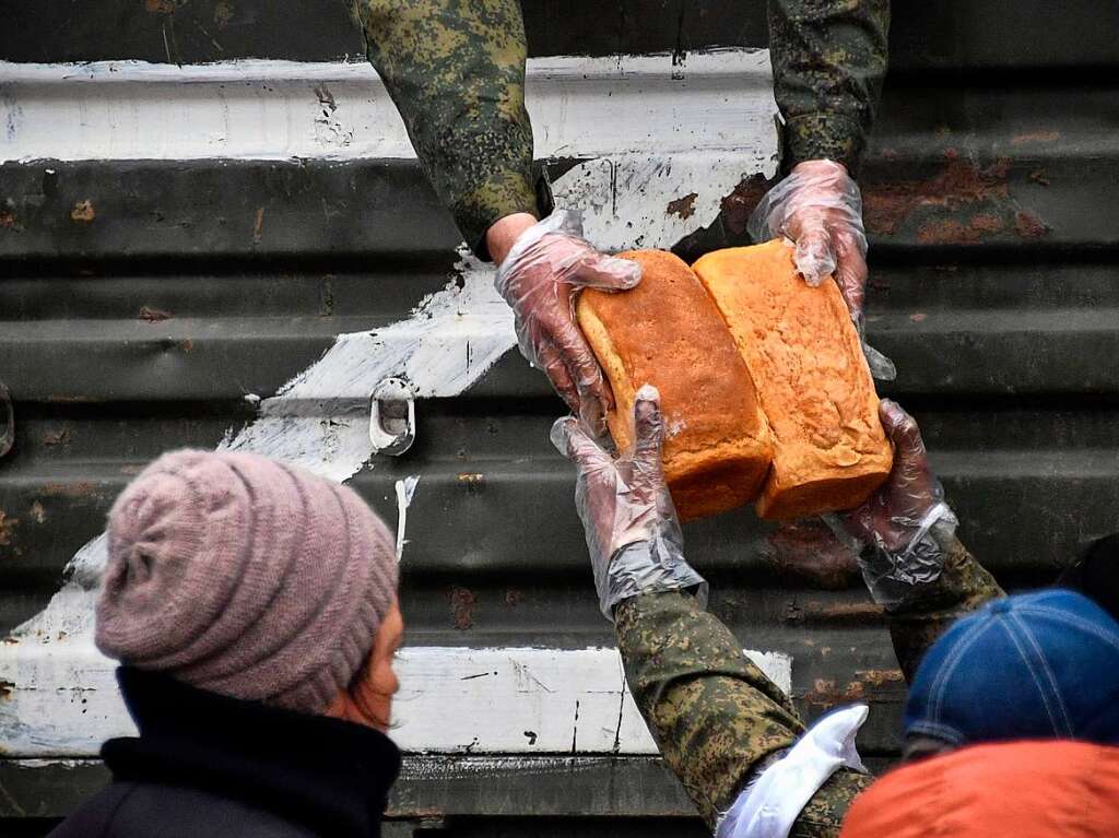 Russische Truppen verteilen Brot – und lassen sich dabei fotografieren.