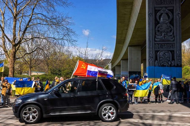 Ein Auto mit sowjetischer, russischer ...an einer pro-ukrainischen Demo vorbei.  | Foto: Philipp von Ditfurth (dpa)