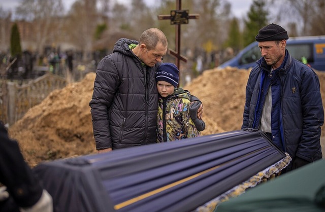 Ukraine, Butscha: Wowa (10) wird von s...itr gestorbenen Mutter Maryna tragen.  | Foto: Emilio Morenatti (dpa)