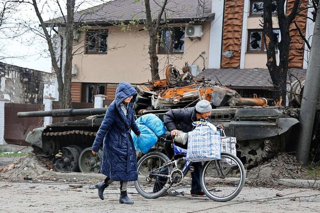 Zivilisten gehen an einem Panzer vorbe...ten Gebiet in Mariupol zerstrt wurde.  | Foto: Alexei Alexandrov (dpa)