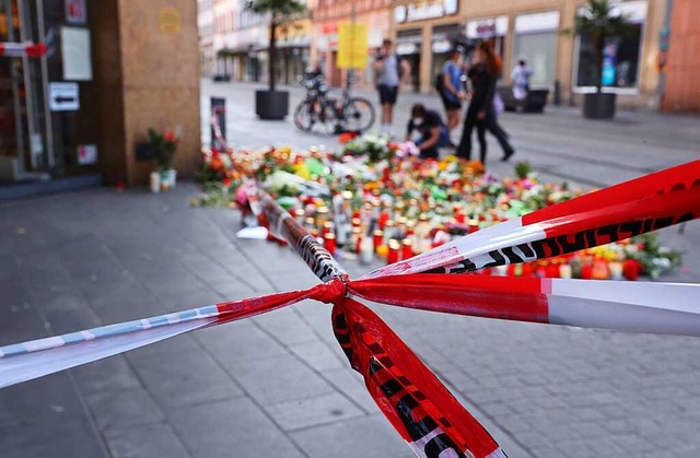 Blumen und Kerzen vor einem abgesperrt...hen mit einem Messer attackiert hatte.  | Foto: Karl-Josef Hildenbrand (dpa)