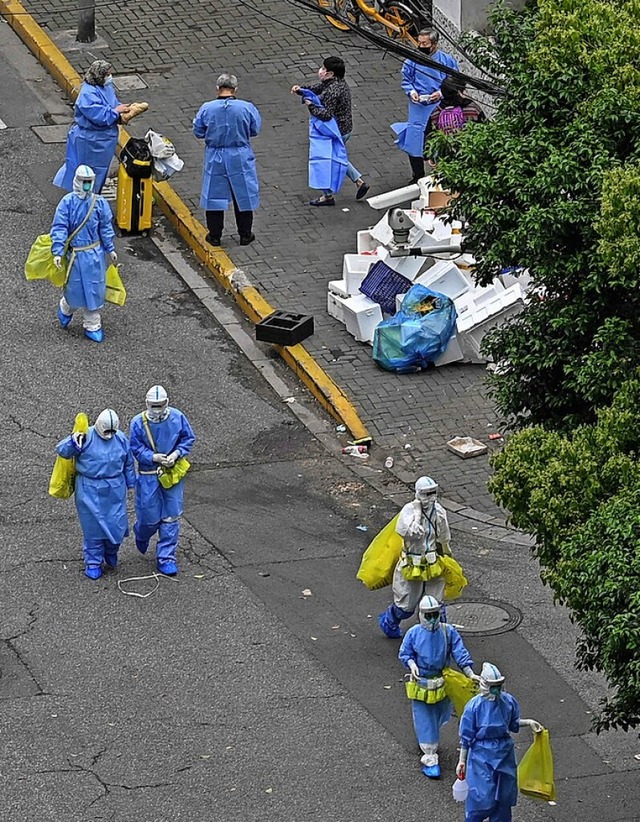 Gesundheitspersonal und Bewohner in Shanghai.  | Foto: HECTOR RETAMAL (AFP)