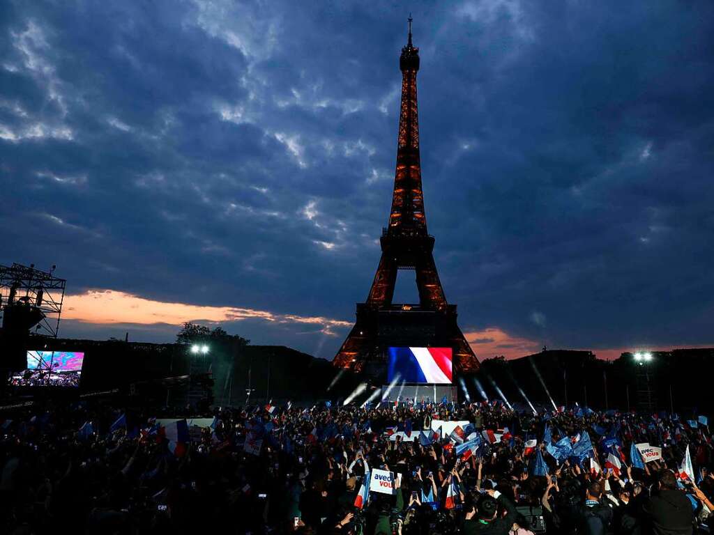 Anhnger des franzsischen Prsidenten Emmanuel Macron feiern am Eiffelturm mit Landesflaggen und Europafahnen.