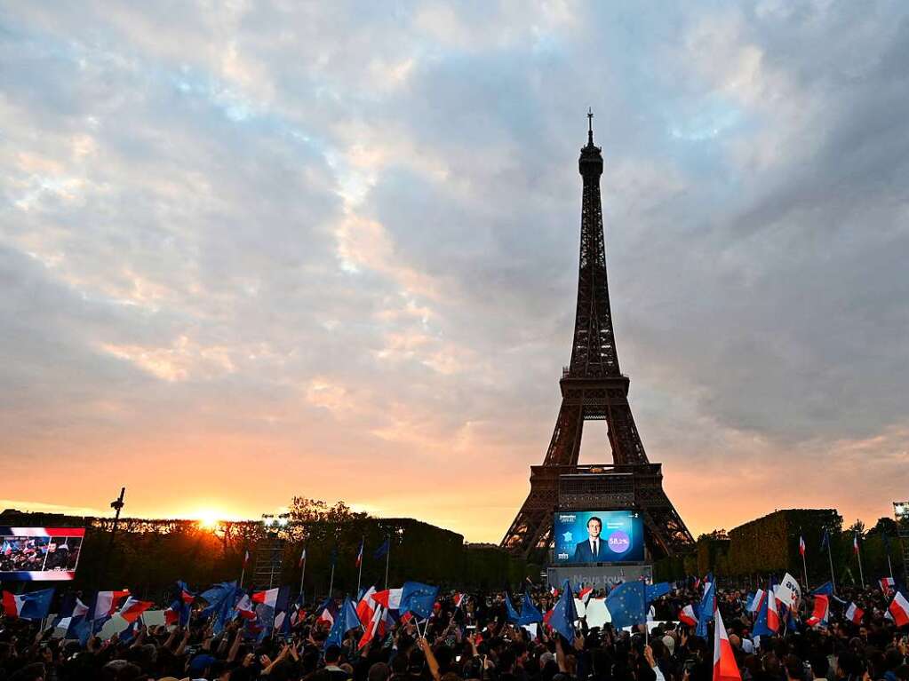 Anhnger des franzsischen Prsidenten Emmanuel Macron feiern am Eiffelturm mit Landesflaggen und Europafahnen.