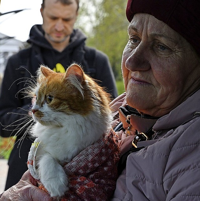Eine Frau hat sich mit ihrer Katze auf die Flucht begeben.  | Foto: Andriy Andriyenko (dpa)