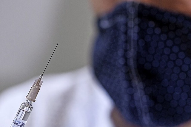 Ein Arzt bei einer Impfung gegen die Grippe  | Foto: Jens Kalaene