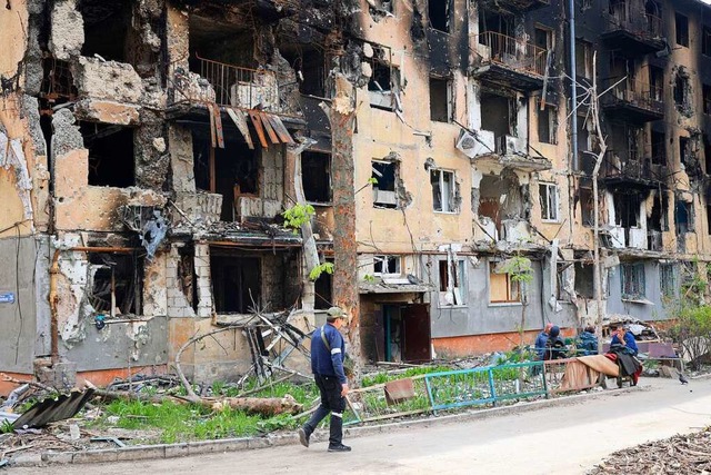 Ein Mann geht an einem zerstrten Wohnhaus in Mariupol vorbei.  | Foto: Alexei Alexandrov (dpa)