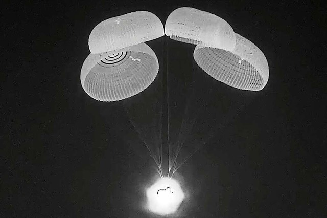 Die &#8222;Crew Dragon&#8220;-Kapsel h...ei ihrer Landung an vier Fallschirmen.  | Foto: - (AFP)