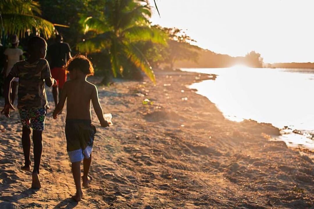 Kinder laufen entlang der Lagune vor ihrem Dorf Crawfish Rock auf Roatán.  | Foto: Paul Gäbler