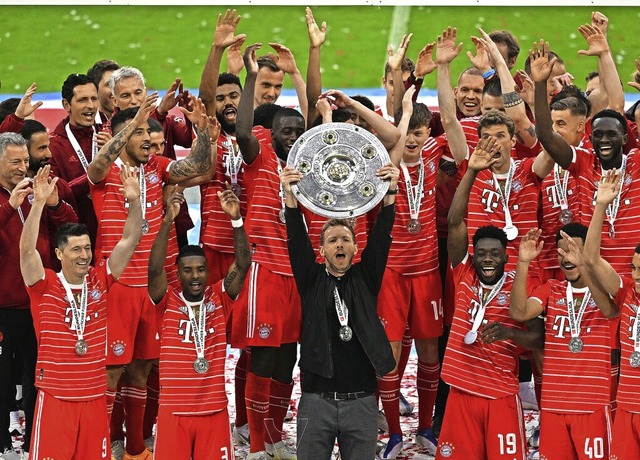 Trainer Julian Nagelsmann hlt die Meisterschale, die Bayern-Spieler jubeln.   | Foto: Sven Hoppe (dpa)