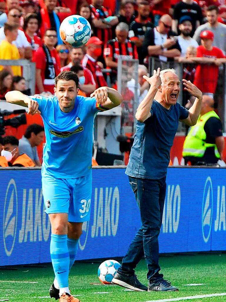 Christian Gnter beim Einwurf, im Hintergrund sieht man seinen Coach Christian Streich.