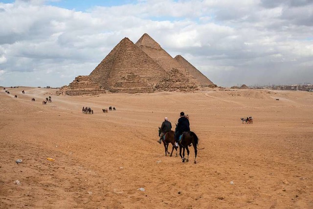 Menschen reiten in der Nhe der drei g...hren-Pyramide und der Cheops-Pyramide.  | Foto: Meng Tao