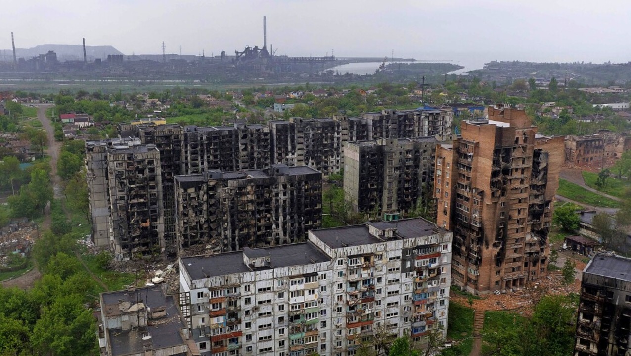 Ein zerstörtes Wohngebiet in Mariupol,... ist das umkämpfte Stahlwerk zu sehen.  | Foto: ANDREY BORODULIN (AFP)