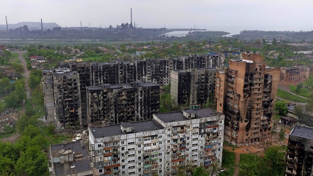 Ein zerstrtes Wohngebiet in Mariupol,... ist das umkmpfte Stahlwerk zu sehen.  | Foto: ANDREY BORODULIN (AFP)