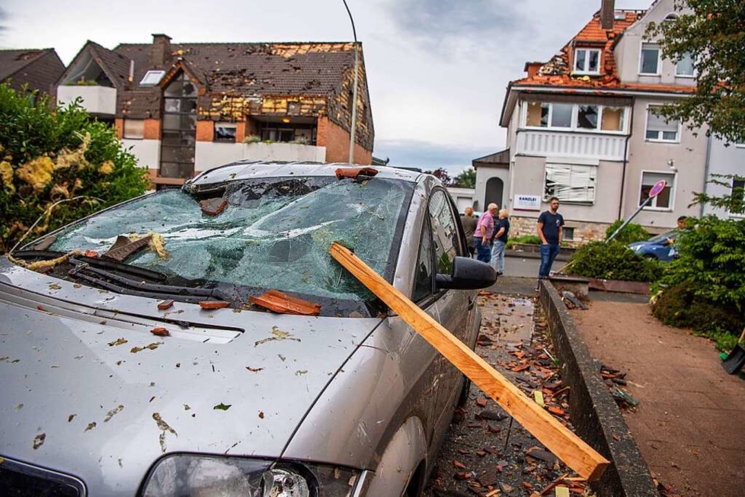 Eine Dachlatte steckt in der Windschut...be eines parkenden Autos in Paderborn.  | Foto: Lino Mirgeler (dpa)