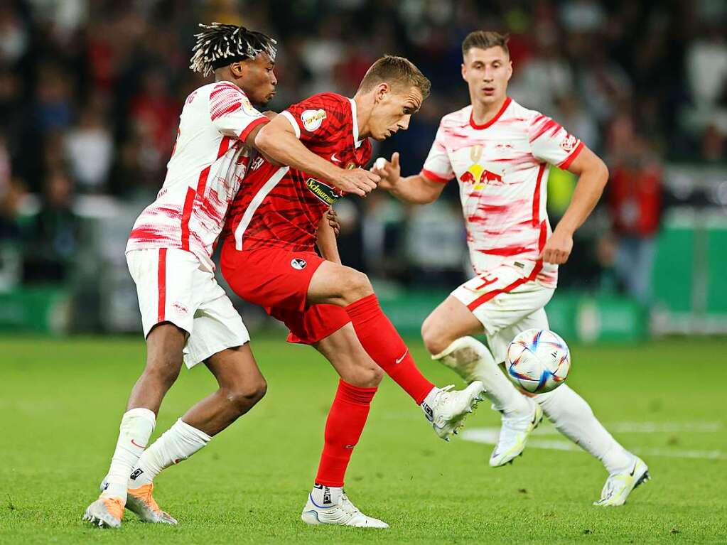 Freiburgs Nils Petersen  und Leipzigs Mohamed Simakan kmpfen um den Ball.