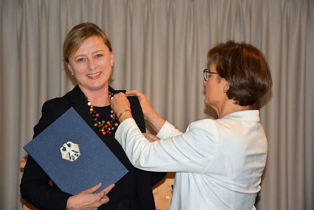 Staatssekretrin Sabine Kurtz heftet  ...Bundesrepublik Deutschland ans Revers.  | Foto: Thomas Biniossek