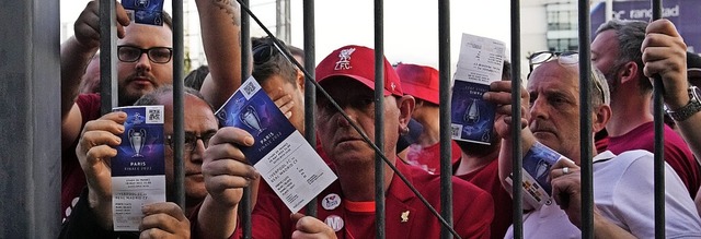 Liverpool-Fans zeigen ihre Eintrittskarten und warten vor dem Stade de France.   | Foto: Christophe Ena (dpa)