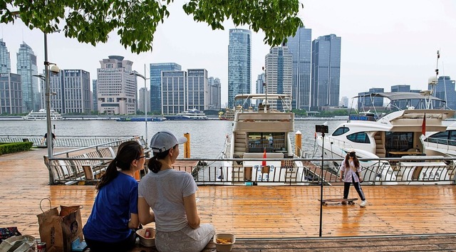 Bewohnerinnen von Shanghai am Huangpu-Fluss   | Foto: LIU JIN (AFP)