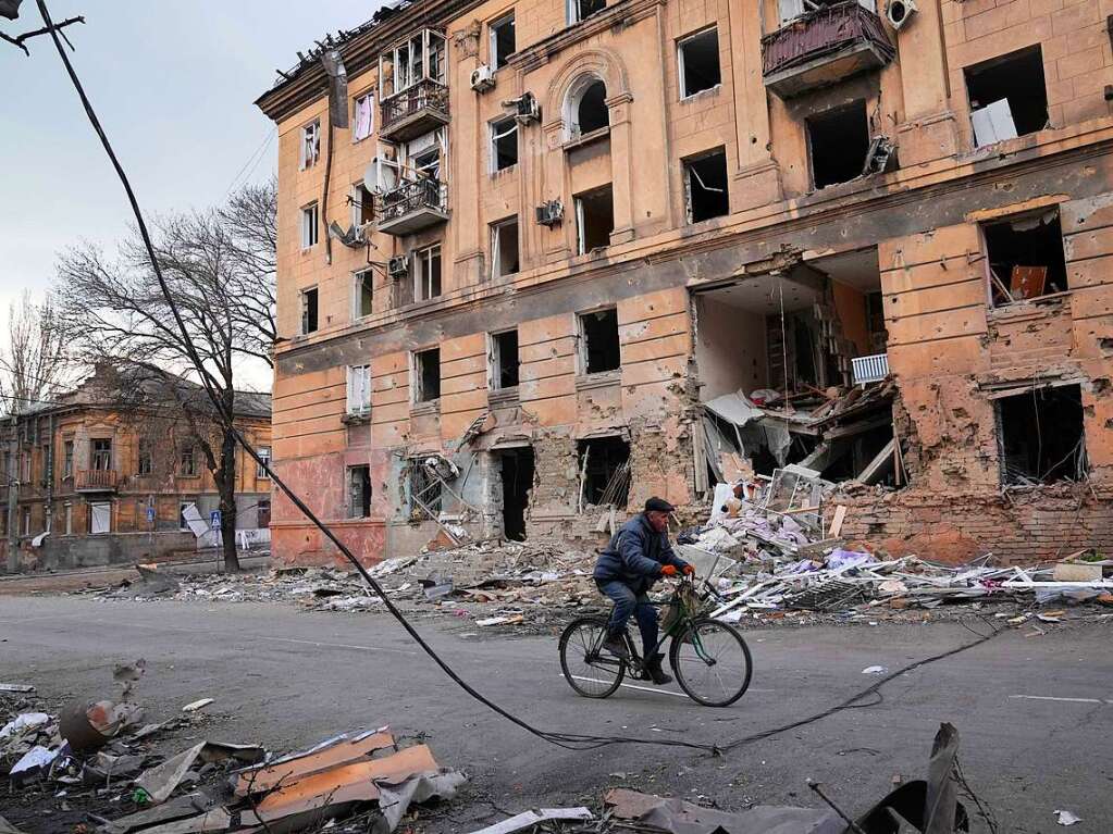 9. Mrz: In Mariupol fhrt ein Mann mit dem Fahrrad an einem durch einen Angriff beschdigten Wohnhaus vorbei.